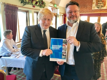 Cllr Lewis with Home Secretary Boris Johnson MP and the manifesto